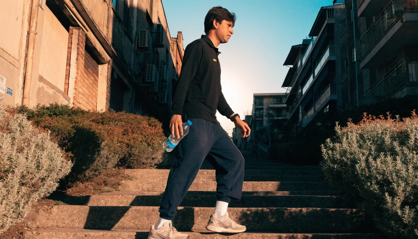 Hombre caminando por unas escaleras exteriores al amanecer como parte de su rutina diaria